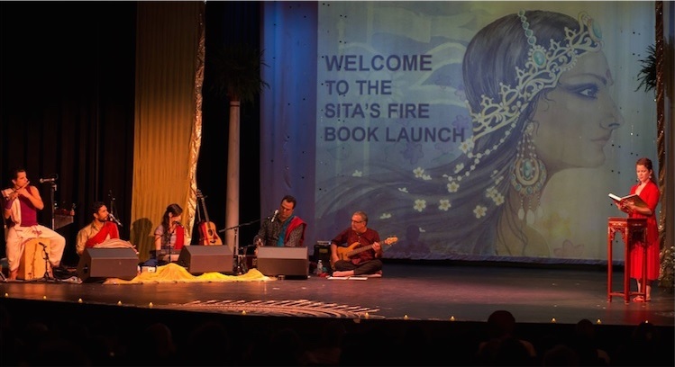 Вринда читает из книги, в то время как на сцене играет живая музыка и иллюстрации проецируются на экран.